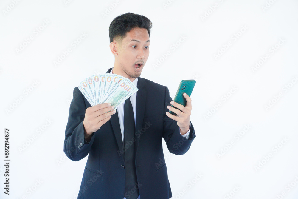 Online profit. Happy young man holding smartphone and dollar cash, enjoying financial success, recommending new mobile app, standing on white background Online profit. Happy young man holding smartphone and dollar cash, enjoying financial success, recommending new mobile app, standing on white background
