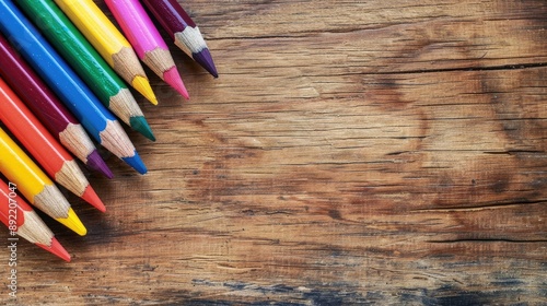 Coloring pencils displayed on a wooden surface with space for writing photo