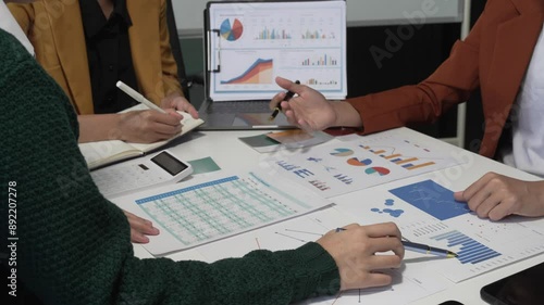 A group of people collaborates around a desk, discussing and reviewing user interface (UI) and user experience (UX) elements. usability, accessibility, and design principles for product development. photo