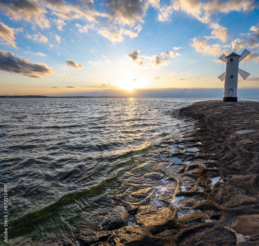 old windmill in Swinoujscie over Baltic sea during sunset in Poland