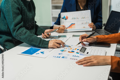 A group of people collaborates around a desk, discussing and reviewing user interface (UI) and user experience (UX) elements. usability, accessibility, and design principles for product development. photo