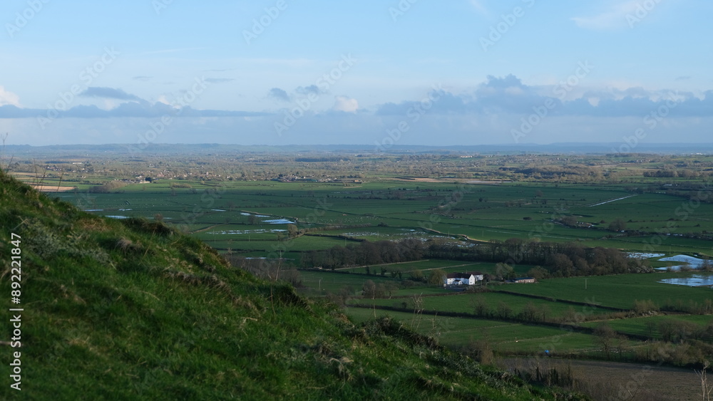 Scenic view from The Tor overlooking green agricultural farmland and fields of the Somerset Levels in West Country of England UK Scenic view from The Tor overlooking green agricultural farmland and fields of the Somerset Levels in West Country of England UK