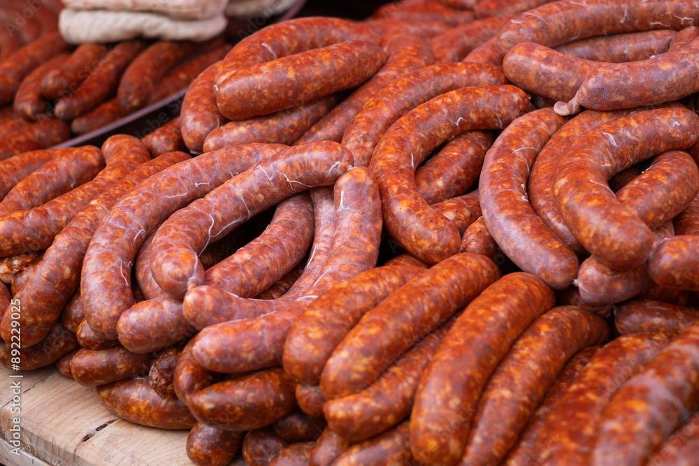 Homemade sausages of pork smoked and dried stand on the table for sale. Homemade sausages of pork smoked and dried stand on the table for sale.