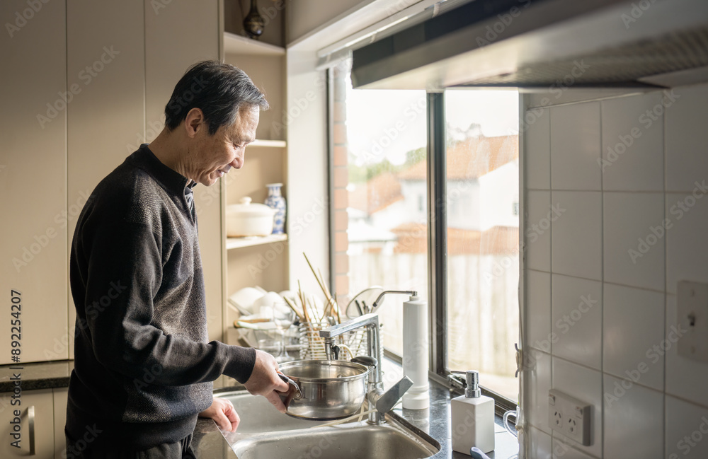 Man filling cooking pot with water at sink in kitchen. Man filling cooking pot with water at sink in kitchen.