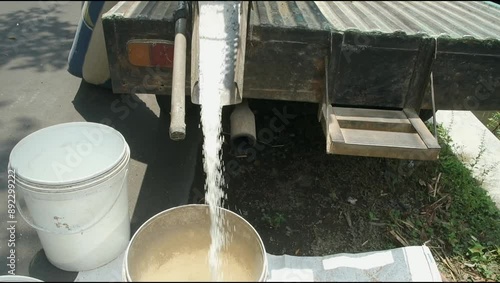Milled rice grains, rice is poured into buckets for processing. 