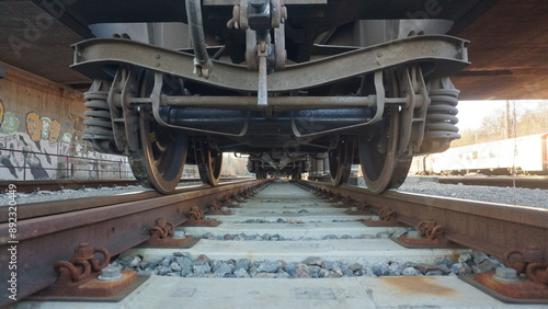 Zug von unten, Zug auf den Gleisen, Bahngleise unter einem Zug. 