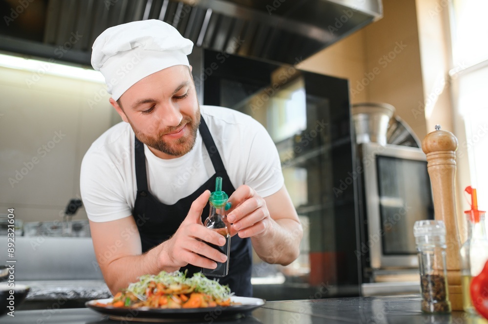 Portrait of handsome positive chef cook at the restaurant kitchen Portrait of handsome positive chef cook at the restaurant kitchen