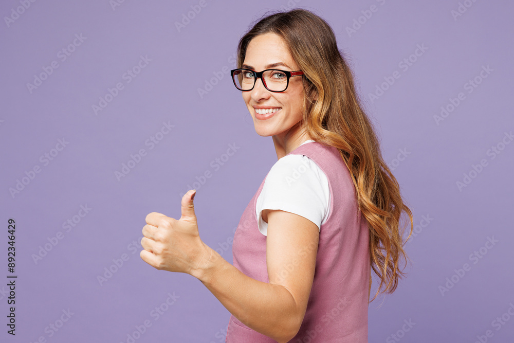 Back side view young fun successful employee business woman wear white t-shirt vest glasses showing thumb up like gesture isolated on plain pastel purple background studio. Achievement career concept. Back side view young fun successful employee business woman wear white t-shirt vest glasses showing thumb up like gesture isolated on plain pastel purple background studio. Achievement career concept.