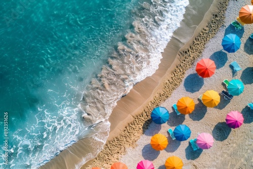 Brightly colored umbrellas on a sandy beach, with the sun high in the sky and clear, inviting ocean waters beyond