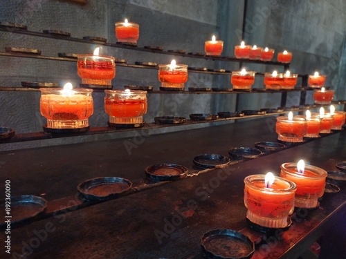 Burning candles in church. Religious theme, death, grief, remembrance, faith, hope, praying. Ritual of lighting a candle. Keeping a light burning in remembrance signifies that memory still lives on.