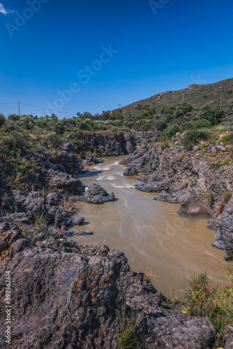 The place near Ponte dei Saraceni. An ancient medieval bridge of Norman age located on the Simeto river. Adrano - Catania, in Sicily. Long exposure picture. June 2023 photo