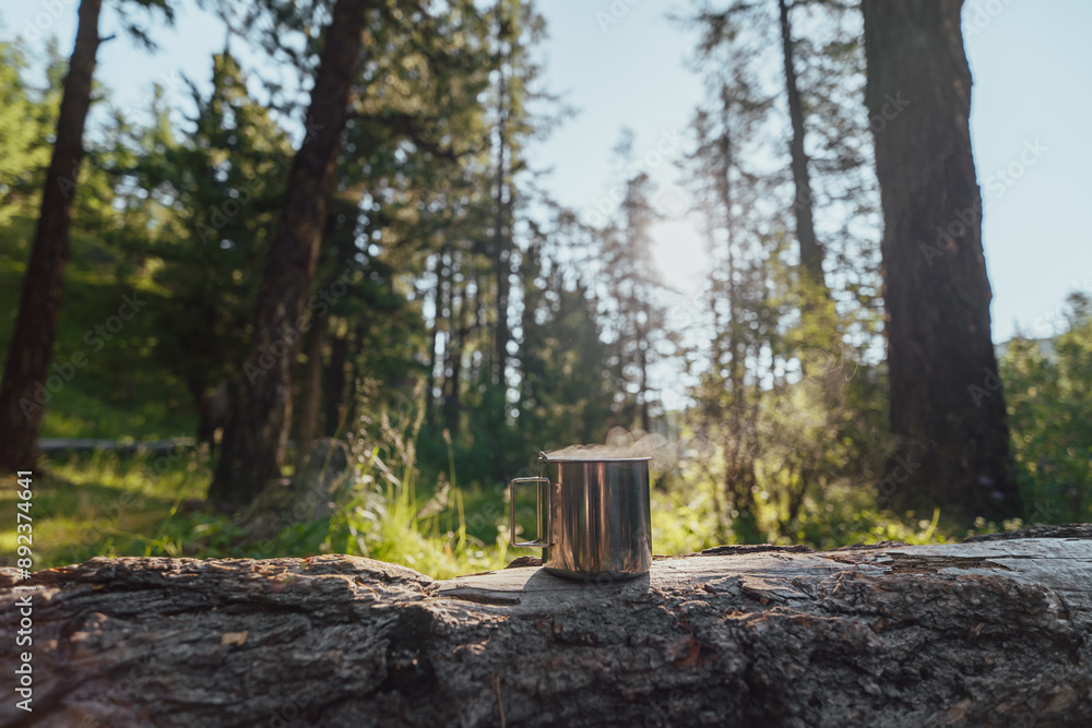 Fototapeta premium Steel mug of morning coffee in forest 
