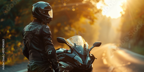 Biker wearing protective gear standing by motorcycle on road