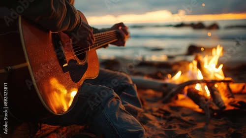 Playing a guitar on a beach around a bonfire at night