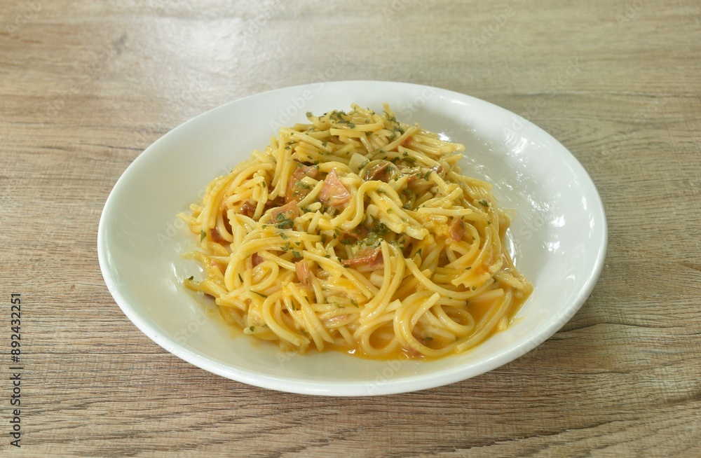 fried spaghetti slice ham pork with chop garlic in carbonara cheese cream sauce on plate fried spaghetti slice ham pork with chop garlic in carbonara cheese cream sauce on plate