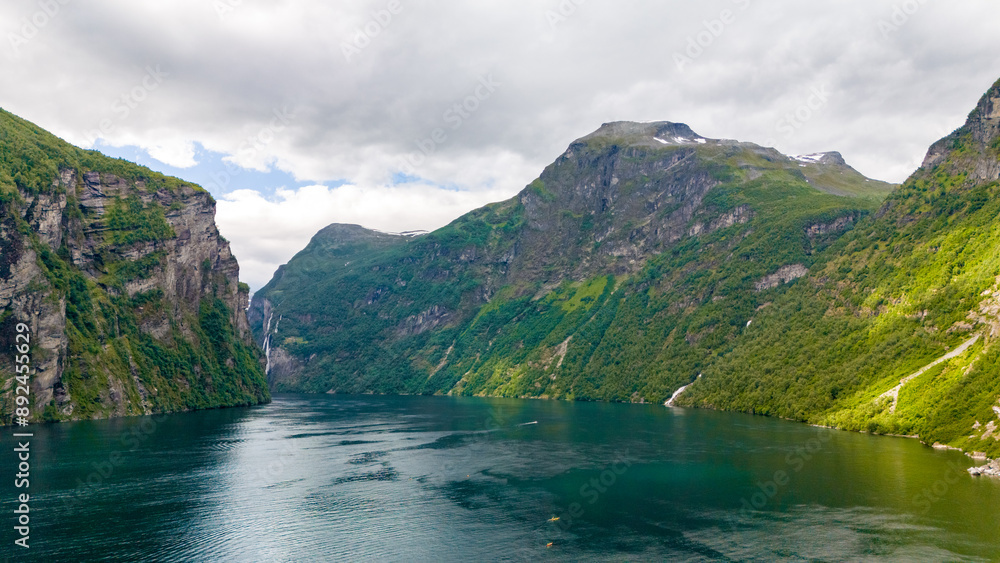A serene view of a fjord in Norway, with verdant slopes and a glassy, emerald water surface. lovatnet lake Lodal valley Norway A serene view of a fjord in Norway, with verdant slopes and a glassy, emerald water surface. lovatnet lake Lodal valley Norway