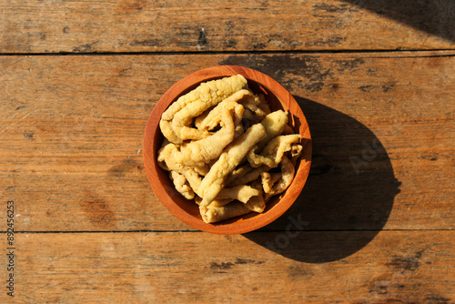 Fried chicken intestines Indonesian food is called usus goreng in a small wooden bowl with wooden background