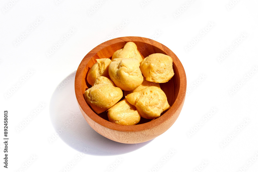 Dry Soes Cake in a small wooden bowl isolated on white background Dry Soes Cake in a small wooden bowl isolated on white background