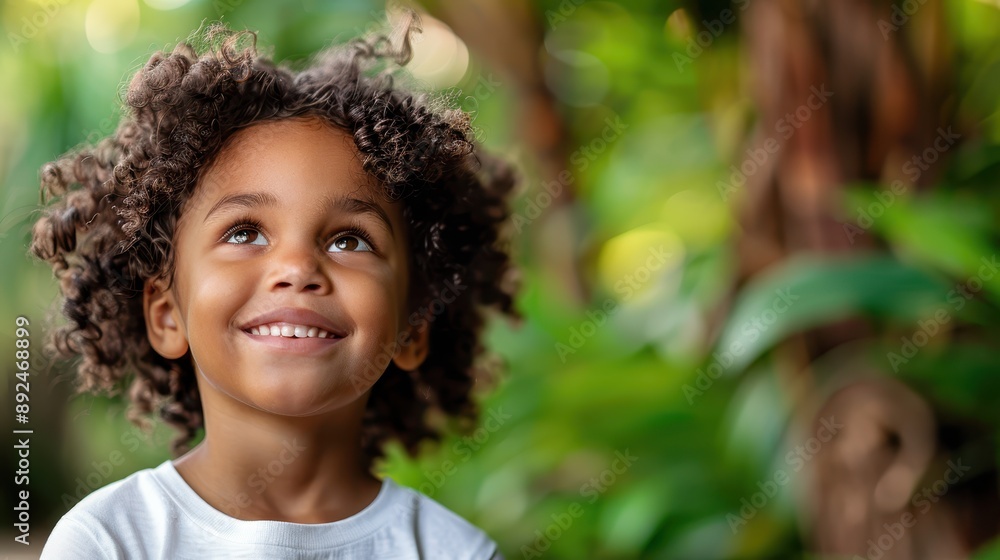 A bright-eyed child with curly hair looking up with a smile, surrounded by lush green foliage. The child's expression captures wonder and happiness in a natural setting. A bright-eyed child with curly hair looking up with a smile, surrounded by lush green foliage. The child's expression captures wonder and happiness in a natural setting.