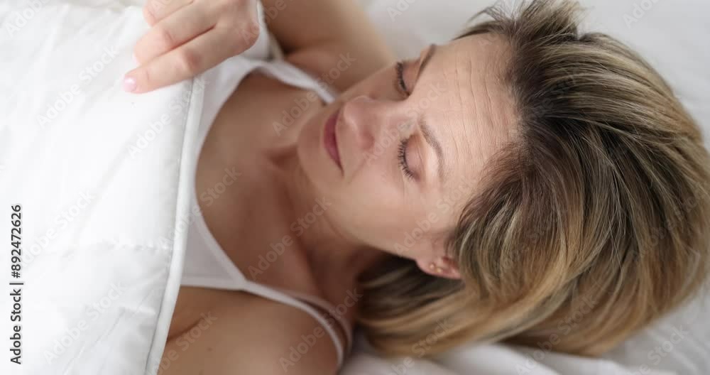 Awakened frightened woman looks under covers. Bleeding in early pregnancy causes concept Awakened frightened woman looks under covers. Bleeding in early pregnancy causes concept