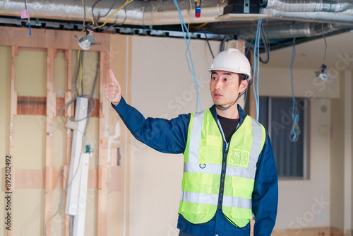 工事現場で安全服を着て作業をする男性大工 photo