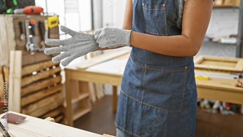 African woman wearing safety gloves in a carpentry workshop