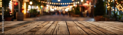 Empty wooden table in outdoor street market with festive string lights, perfect for product display or background for holiday season activities. photo