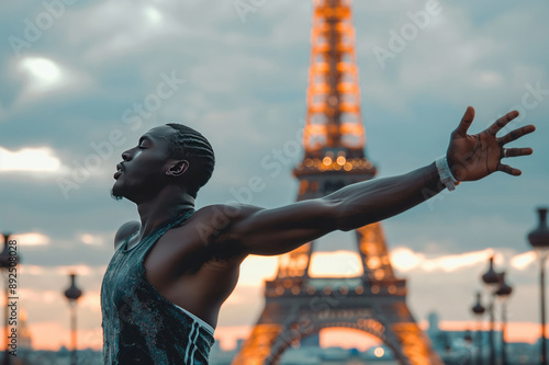 Black African American athlete with arms wide open celebrating his victory near the Eiffel Tower in Paris, France. photo