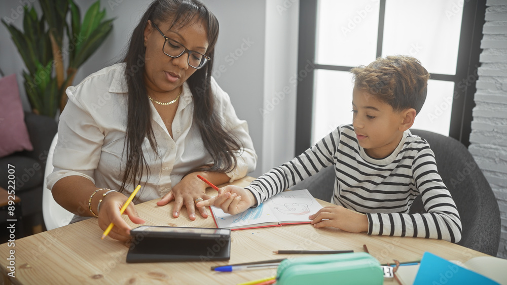 A woman guides her son in drawing activities at a wooden table inside a cozy living room, symbolizing a nurturing family environment. A woman guides her son in drawing activities at a wooden table inside a cozy living room, symbolizing a nurturing family environment.