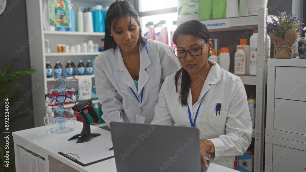 Female pharmacists working together on a laptop in a pharmacy shop, focusing on inventory management and customer service. Female pharmacists working together on a laptop in a pharmacy shop, focusing on inventory management and customer service.