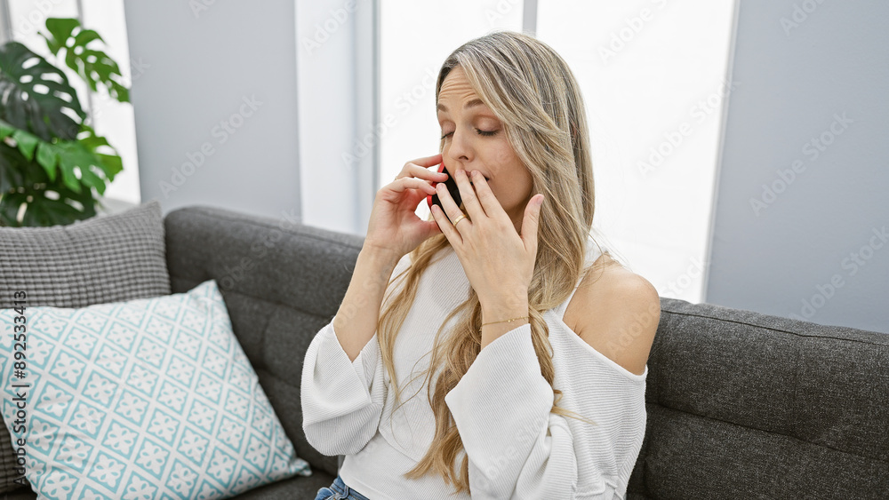 Caucasian woman talking on the phone in her modern indoor living room Caucasian woman talking on the phone in her modern indoor living room