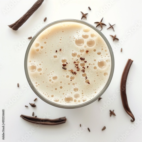 Top view of a vanilla protein shake with star anise and vanilla beans. Perfect for health blogs and fitness drink promotions.