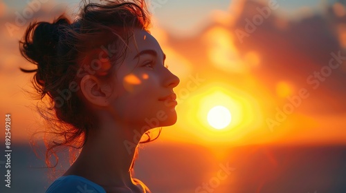 Young woman with her face turned towards the rising sun, capturing the tranquility of the morning light