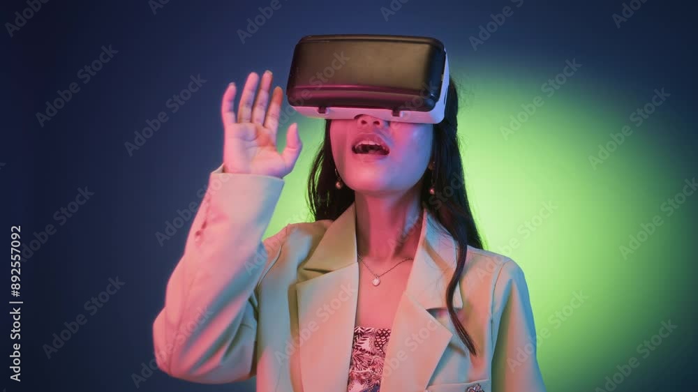 Medium shot of young woman in elegant outfit playing video game in VR headset isolated on neon background Medium shot of young woman in elegant outfit playing video game in VR headset isolated on neon background