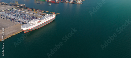 Aerial drone photo of large car carrier ro ro vessel guided by tug boats to dock to Mediterranean port.
