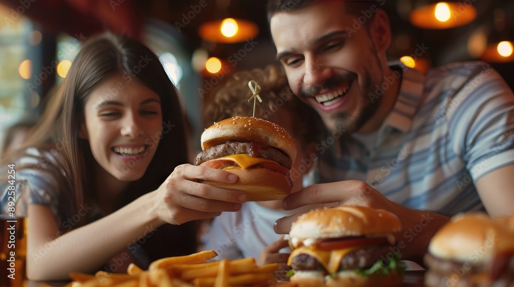 Smiling Family Eating Cheeseburgers Together in Restaurant Smiling Family Eating Cheeseburgers Together in Restaurant