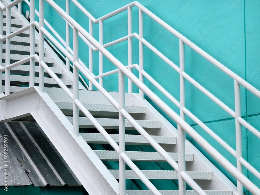 Fototapeta premium Metal stairs to blue building against sky and clouds