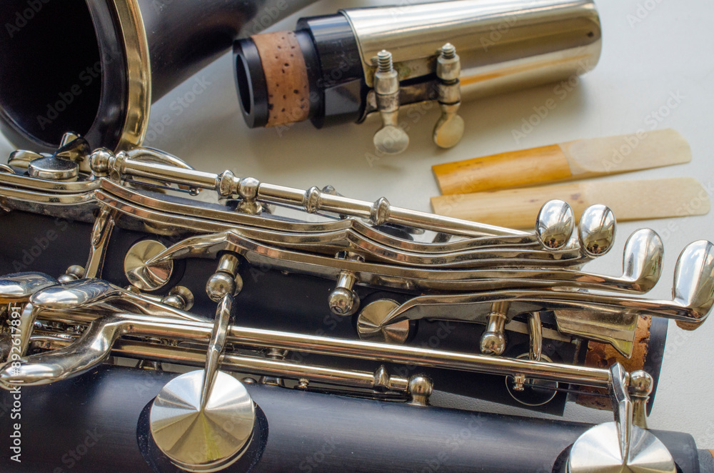 Naklejka premium French system clarinet disassembled and two reeds on a light background