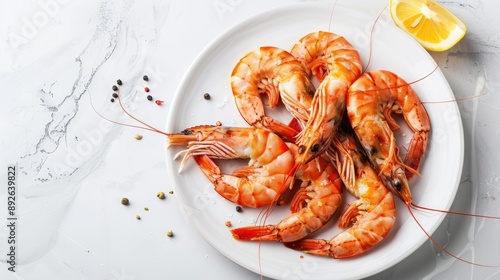 Freshly cooked shrimps on a white plate, bright background, ample copy space photo