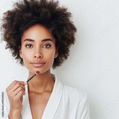 A Black woman in a half-body view, with visible arms, applying makeup to create the aegyo-sal look under her eyes photo