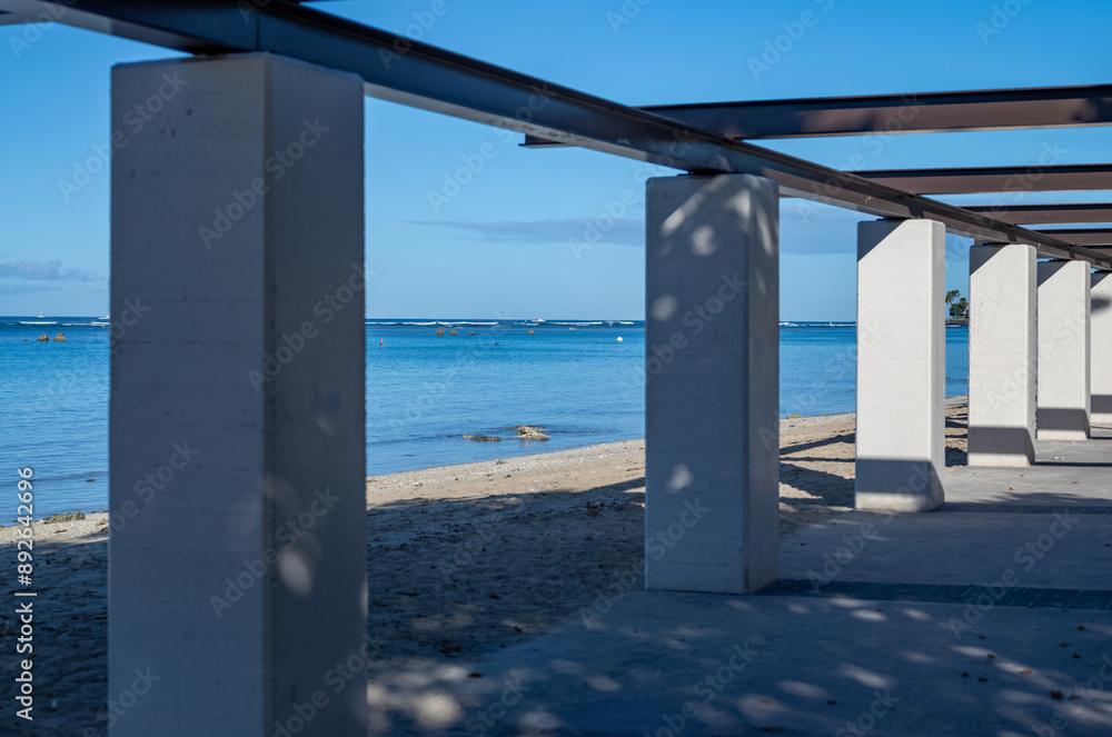 White Columns on a Sand Beach with Shade and Silhouettes. White Columns on a Sand Beach with Shade and Silhouettes.