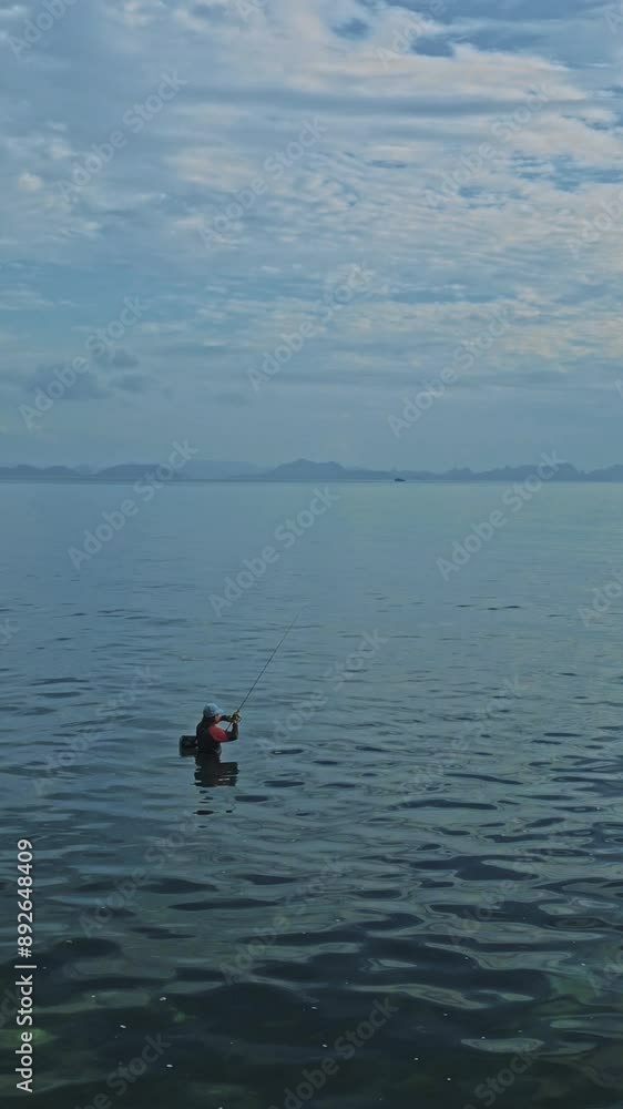 Aerial View of Fisherman in Wetsuit Fishing in the Sea, Islands on Horizon, Clouds in Sky, Samui, Thailand Aerial View of Fisherman in Wetsuit Fishing in the Sea, Islands on Horizon, Clouds in Sky, Samui, Thailand