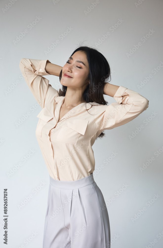 Happy smiling carefree young Asian woman expressing relaxed, soothing, chilling-out emotion with no stress Happy smiling carefree young Asian woman expressing relaxed, soothing, chilling-out emotion with no stress