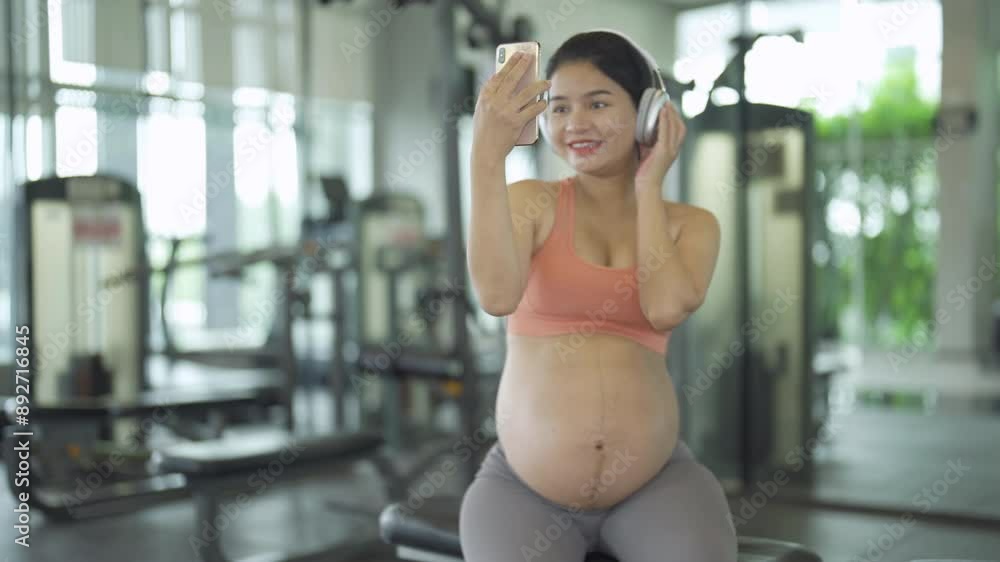 A portrait of happy Asian pregnant woman at gym fitness center club. Having a baby. Training workout. Exercise indoor with sport equipment. Athletic. Family people lifestyle. Mom love. Recreation. A portrait of happy Asian pregnant woman at gym fitness center club. Having a baby. Training workout. Exercise indoor with sport equipment. Athletic. Family people lifestyle. Mom love. Recreation.