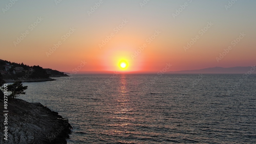 Stunning sunset over the serene coastline with glowing skies and calm ocean waters Stunning sunset over the serene coastline with glowing skies and calm ocean waters