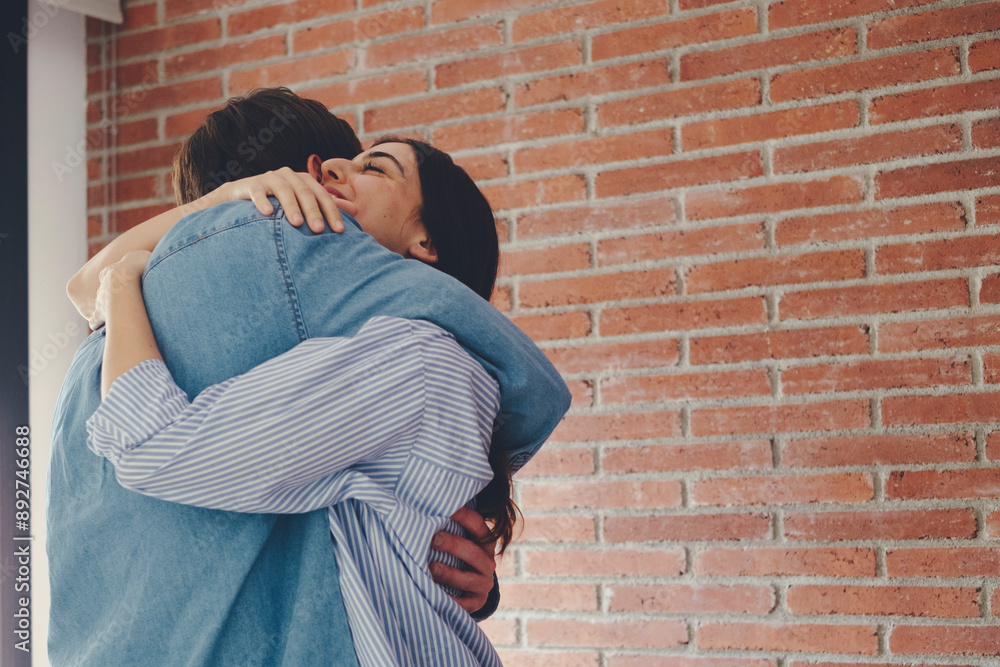 Excited couple hugging each other at home in happy moment indoor. Love and relationship concept. Friendship and celebration. Meet after long time emotion parents brothers sisters Excited couple hugging each other at home in happy moment indoor. Love and relationship concept. Friendship and celebration. Meet after long time emotion parents brothers sisters