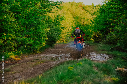 Professional enduro bike rider on action, dirt ride on the muddy track. Motocross sport. 