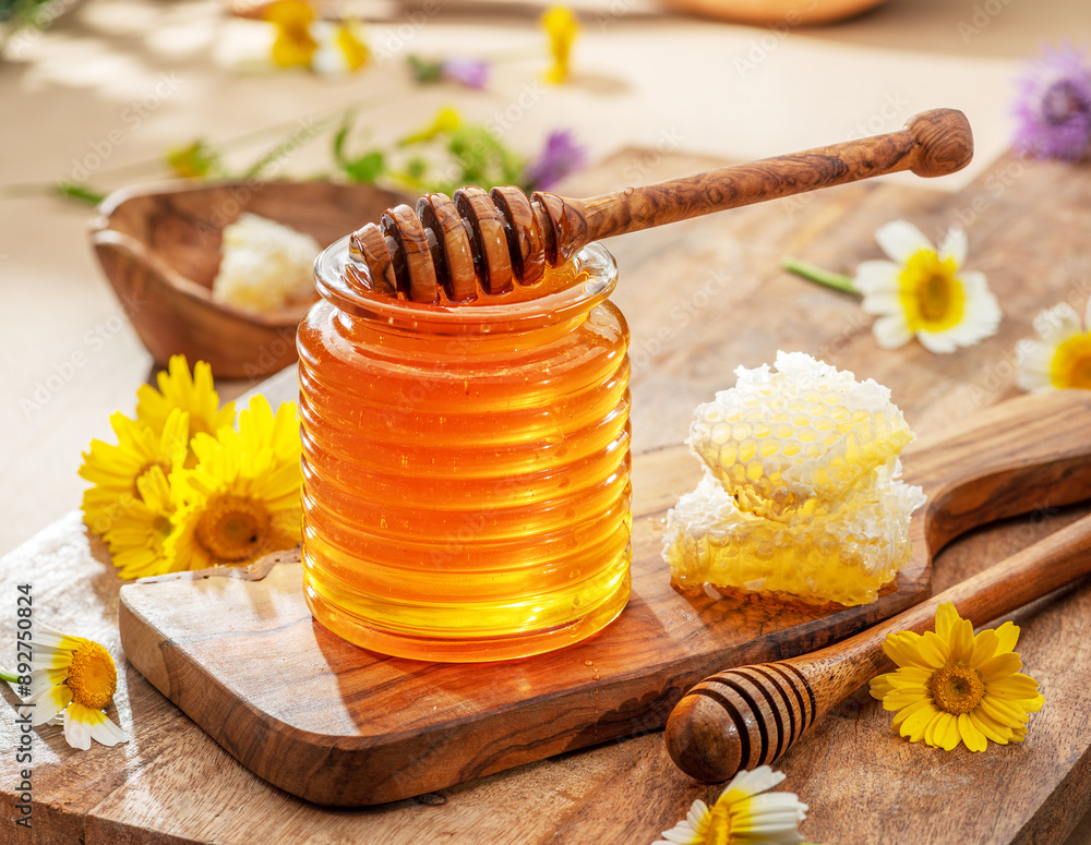 Φωτογραφία Natural organic honey in glass jar, honey dipper and honeycombs are near