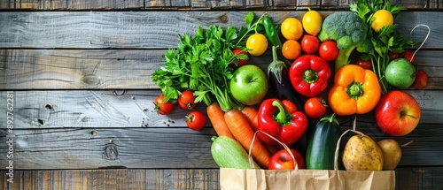A variety of fresh vegetables and fruits overflow from a recycled paper shopping bag, placed on a rustic wooden table