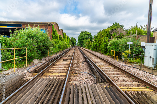 A view down the south coast railway line at a level crossing in Chichester, Sussex in summertime